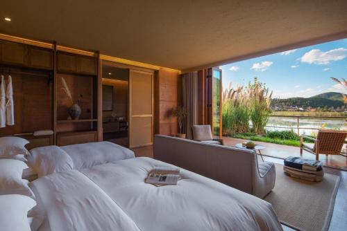 a bedroom with white beds and a large window at Linden Centre Shaxi in Diannan