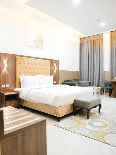 a bedroom with a large bed and a living room at Dream Point Hotel in Fujairah