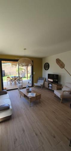 un grand salon avec des canapés et une table dans l'établissement Maison de plage Manoga, à Saint-Germain-sur-Ay