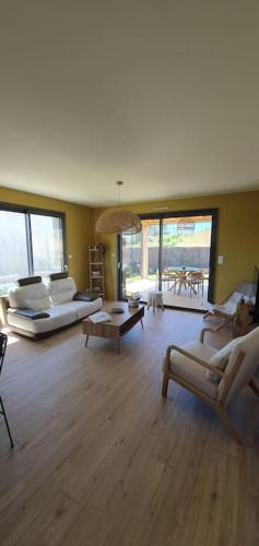 un salon avec deux canapés et une table dans l'établissement Maison de plage Manoga, à Saint-Germain-sur-Ay