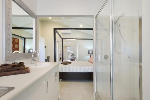 a bathroom with a shower and a sink and a mirror at Best Western Plus The Ranges Karratha in Karratha