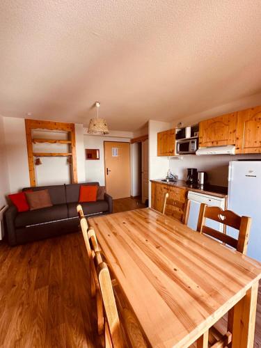 Il comprend une cuisine et un salon avec une table en bois. dans l'établissement Le Tétras Lyre Les Balcons de Recoin, à Chamrousse
