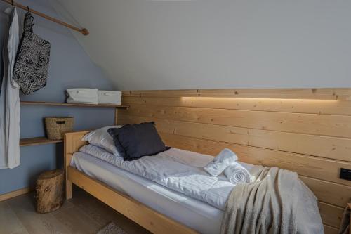 a bed in a wooden room with towels on it at Osada Przystanek Czorsztyn in Czorsztyn