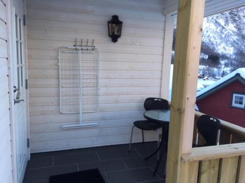 a porch with two chairs and a table and a window at Røldal Hyttegrend & Camping in Røldal