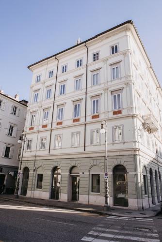 a large white building on the corner of a street at Hotel Vis à Vis in Trieste