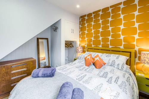 a bedroom with a bed with purple and orange pillows at Gable End in Arundel