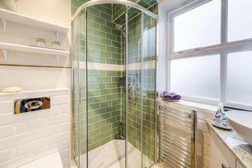 a bathroom with a glass shower and a sink at Gable End in Arundel