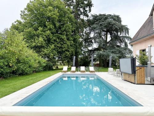 une piscine avec des chaises et une télévision dans une cour dans l'établissement La Meslaysienne - Comfortable house, swimming pool, à Meslay-le-Vidame