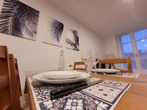 - une table à manger avec des assiettes et des verres à vin dans l'établissement T2 spacieux centre-ville, à Feurs