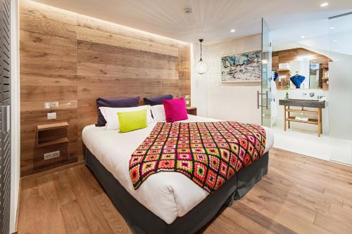 a bedroom with a large bed and a bathroom at Hotel Pashmina Le Refuge in Val Thorens