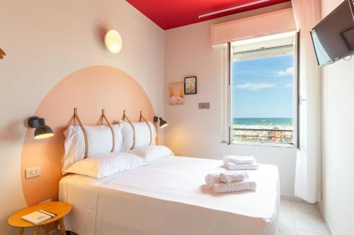 a bedroom with a bed with a view of the ocean at Hotel Belvedere Rimini in Rimini