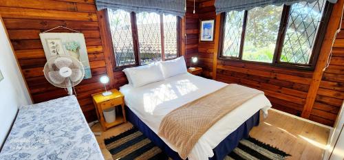 a bedroom with a bed in a log cabin at Milkwood Lodge 10 - Sleeps 4 in Port Edward