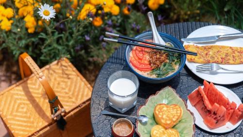 a table with a bowl of food and a bowl of watermelon at Linden Centre Shaxi in Diannan