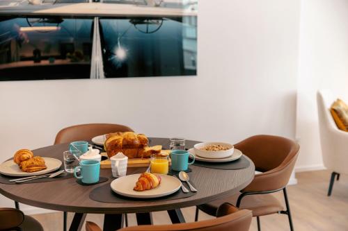 a table with plates of food on it at Media Bay Apartments in Kirchberg by Rentaroo in Luxembourg