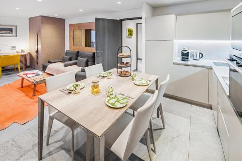 a kitchen and a dining room with a table and chairs at Hotel Pashmina Le Refuge in Val Thorens