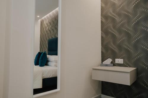 a mirror in a room with a bed and a sink at Marcone Luxury Rooms - Il giardino di pietra in Trani