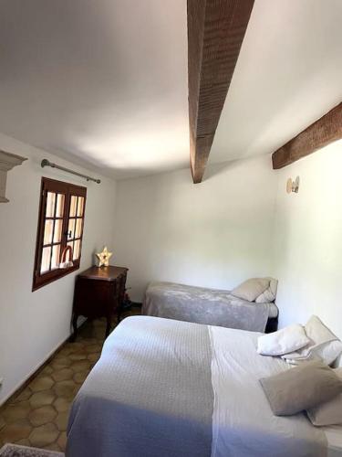une chambre avec deux lits et une fenêtre dans l'établissement Maison Cian en Provence, à Tavernes