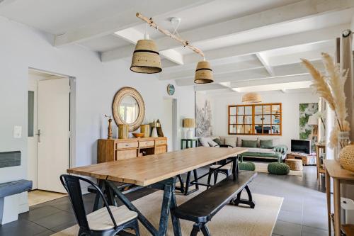 une salle à manger avec une table et des chaises en bois dans l'établissement maison familiale à 2 pas du lac,avec spa, à la Gde Escoure-grives, à Lacanau