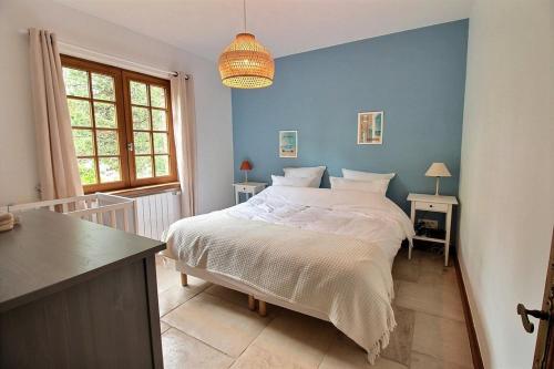 une chambre avec un lit avec un mur bleu dans l'établissement Annonce professionnelle. Jolie maison de vacances 4 chambres avec jardin à proximité de la plage, pour 8 personnes. WIFI, à Hardelot-Plage
