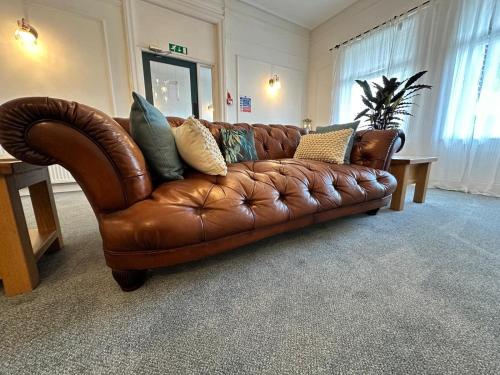 a brown leather couch sitting in a living room at The Briarcroft in Goole