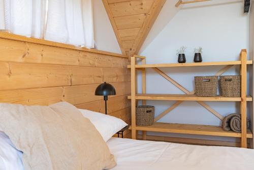 a bedroom with a bed and a wooden wall at Osada Przystanek Czorsztyn in Czorsztyn