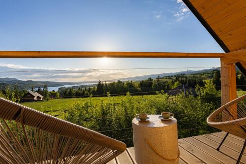 a deck with chairs and a view of the mountains at Osada Przystanek Czorsztyn in Czorsztyn