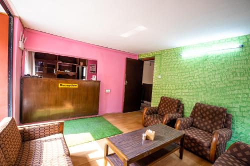 a waiting room with chairs and a table and a bar at Hotel Harmony & Little Bites Bistro in Pātan