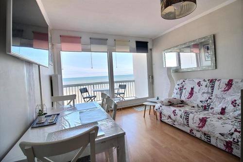 - un salon avec une table et un canapé offrant une vue dans l'établissement Annonce professionnelle. Agréable Studio cabine 4ème étage front de mer, pour 3 personnes maxi à HARDELOT PLAGE., à Hardelot-Plage