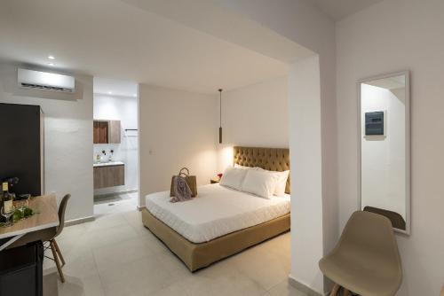 a bedroom with a bed and a desk in a room at Chrysonisos Suites with Sunset & Seaviews near Kini in Ano Syros