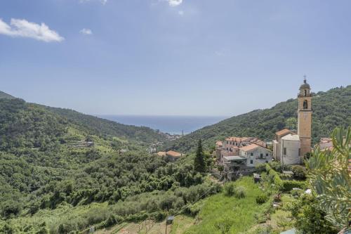 a town on a hill with a clock tower at Emma House Terrace and Sea View Moneglia in Moneglia