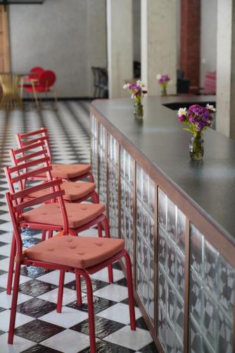 a row of red chairs sitting at a counter at Station 22 Hotel in Batumi