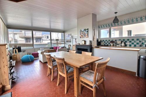 une cuisine avec une table et des chaises dans une pièce dans l'établissement Annonce professionnelle. Maison idéalement située à 100 m de la plage, 3 chambres, 7 couchages max., à Hardelot-Plage