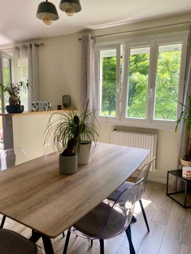 une salle à manger avec une table et des chaises en bois dans l'établissement Bel appartement Nantes, à Nantes
