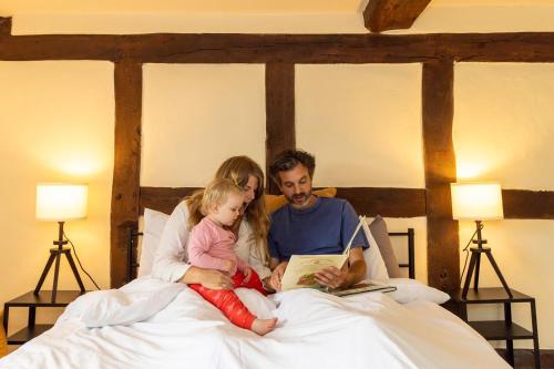 a man and woman sitting on a bed reading a book at River Fishing I Hot tub I Games Room I PetFriendly in Rainow