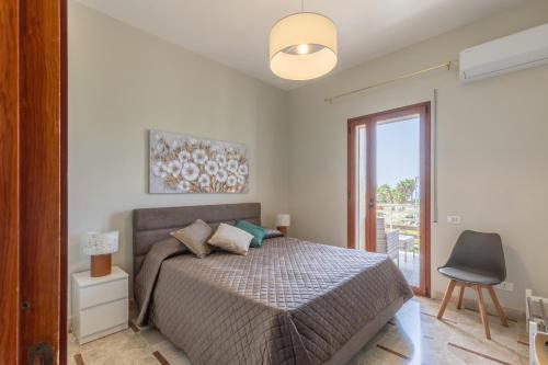 Un dormitorio con una cama y una puerta corrediza de vidrio. en Terranova Home vista mare, en San Leone