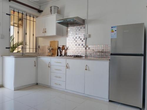 a kitchen with white cabinets and a refrigerator at Morsky Vanek Apartment in Flic-en-Flac