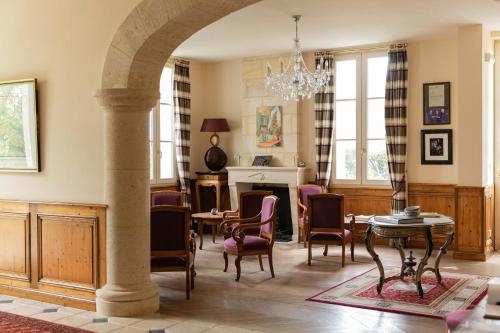un salon avec une table et des chaises dans l'établissement Villa Héloïse Hôtel de Charme, à Puisseguin