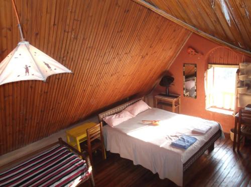 a bedroom with a bed and a table and a window at Le Karthala Chambres D'Hotes in Antananarivo