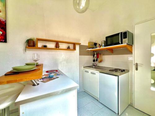 une petite cuisine avec un réfrigérateur et un micro-ondes dans l'établissement Studio centre Historique, Gare à proximité, à Nîmes