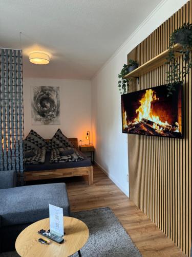 a living room with a fireplace on the wall at Residenz am Kurpark - Ferienwohnungen in zentraler Lage I Privatparkplatz in Bad Rothenfelde