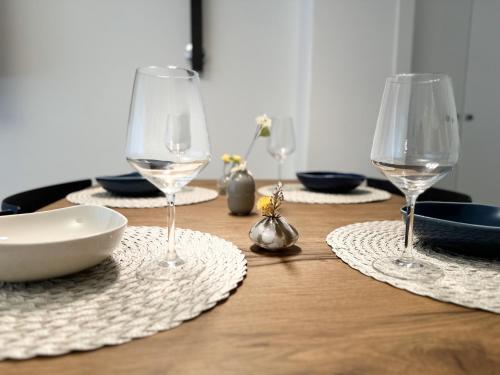 a table with two wine glasses and plates on it at Como Charme Apartment in Como