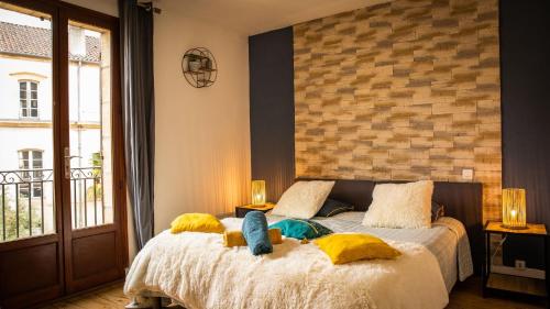 une chambre avec un lit avec deux poupées dessus dans l'établissement Le Sarladais - Coeur de Sarlat, à Sarlat-la-Canéda