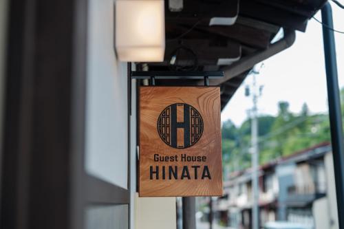 a sign for a guest house himachi hanging on a building at Guest House HINATA - Japanese House with Sauna and Open-air Bath in Takayama