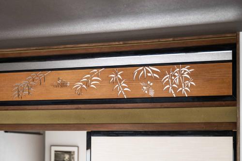 a wooden window frame with a depiction of bamboo at Guest House HINATA - Japanese House with Sauna and Open-air Bath in Takayama