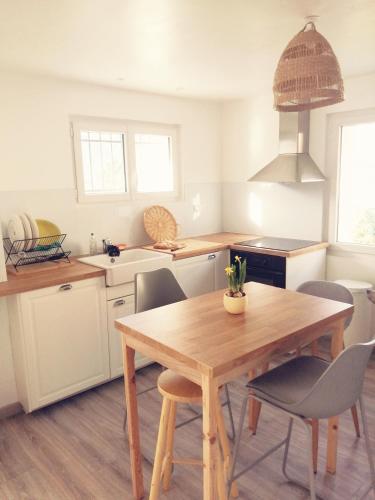 une cuisine avec une table et des chaises en bois dans l'établissement Magnifique T3, entre lac et montages, Embrun, à Embrun