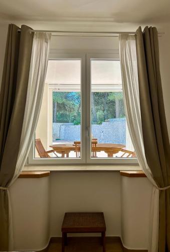 a window with curtains and a table in a room at Villa Buon Vento in Vignacastrisi