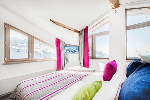 a room with a couch and windows with mountains at Hotel Pashmina Le Refuge in Val Thorens
