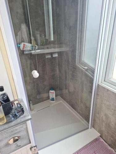 une salle de bain avec une douche avec un lavabo et une douche dans l'établissement Bungalow charmant à Sigean avec piscine et jardin clôturé, à Sigean