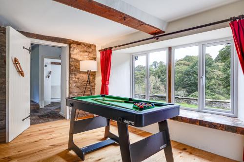a room with a pool table in a room with windows at River Fishing I Hot tub I Games Room I PetFriendly in Rainow