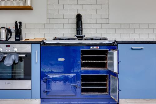 a blue oven in a kitchen next to a stove at River Fishing I Hot tub I Games Room I PetFriendly in Rainow